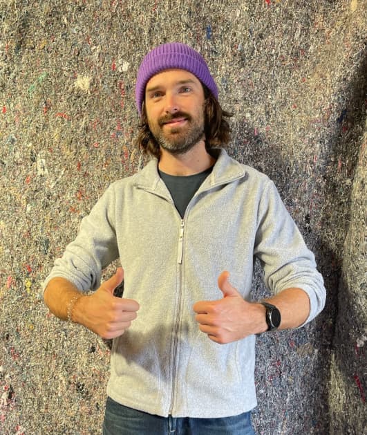 Image of a man standing in front of a moving blanket.